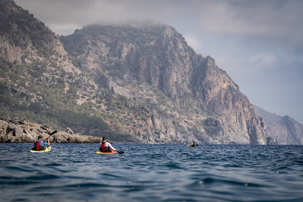 Seekajakfahrer von hinten vor der Steilküste Kretas
